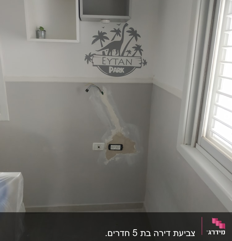 קיר צבוע עם תיקון טיח וציור דינוזאור